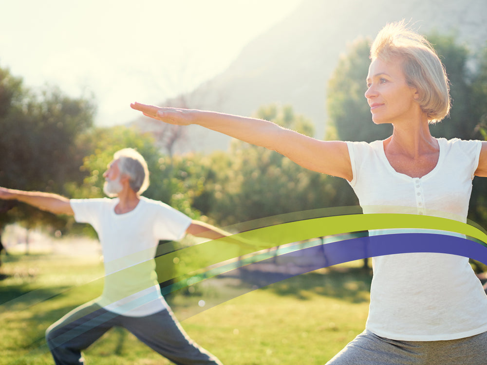 Older couple stretching in the park with lime green and purple arc over their midsections